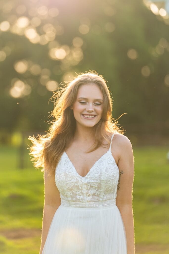 woman in white spaghetti strap top smiling
